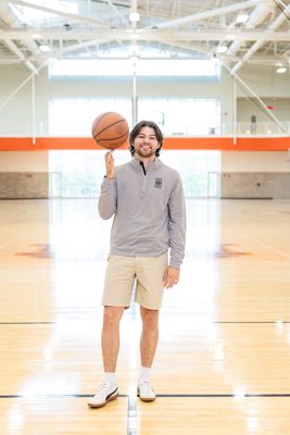 a man standing on a basketball court holding a basketball