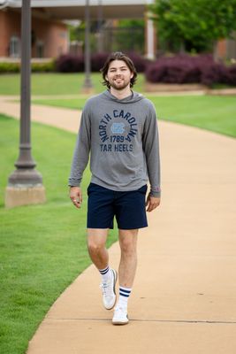 a man walking down a sidewalk in front of a building