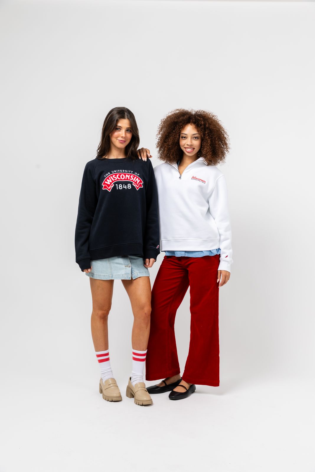 two women standing next to each other in front of a white background