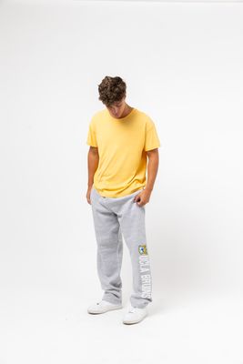 a man in a yellow shirt and grey sweatpants