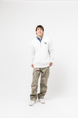 a boy in a white sweatshirt and camo pants