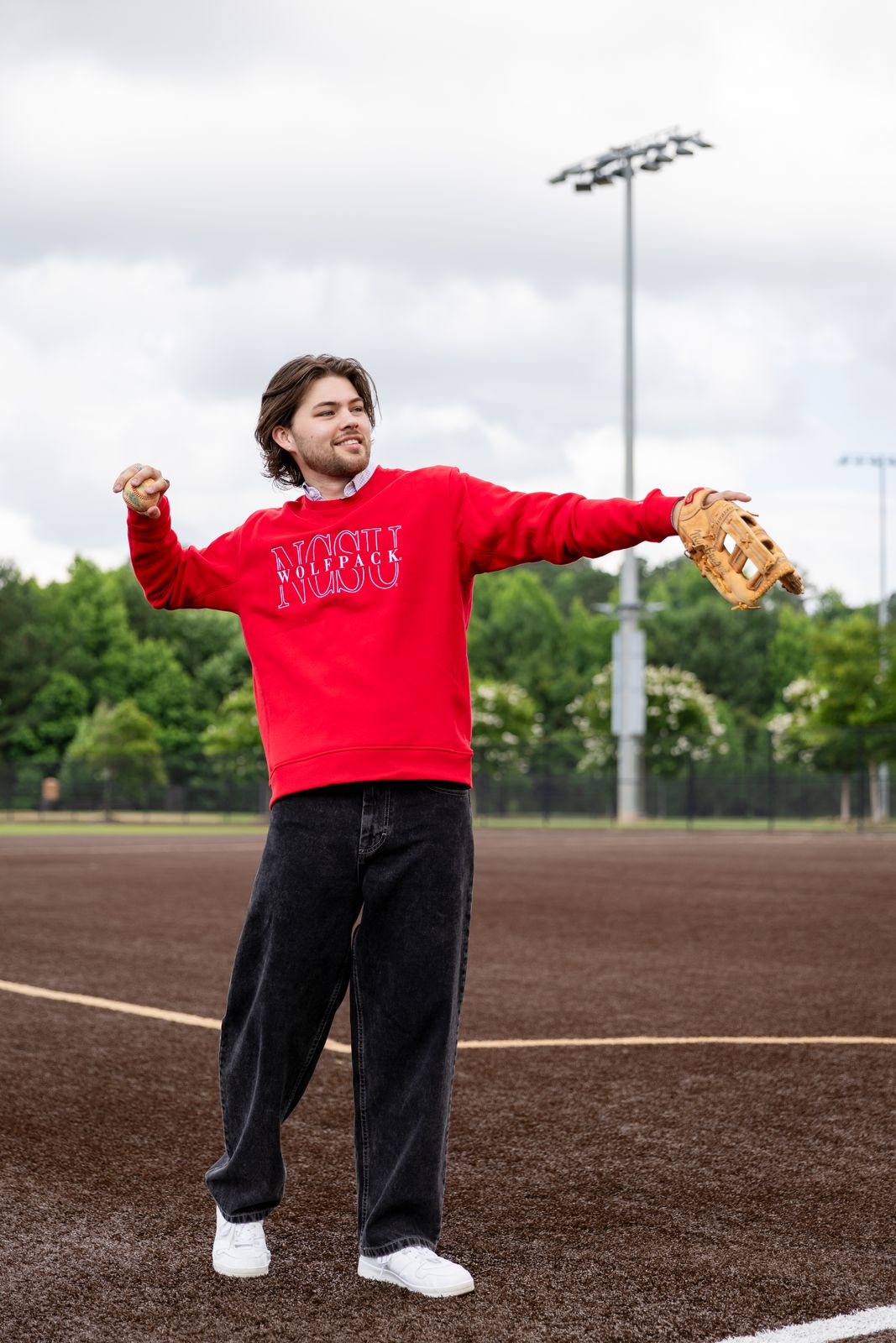 a man standing on a baseball field holding a catchers mitt