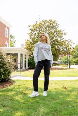 a woman standing in the grass in front of a building
