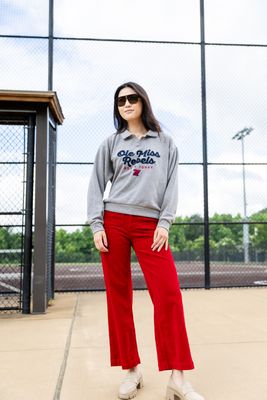 a woman in a gray sweatshirt and red pants