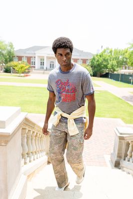 a young man is standing on a porch