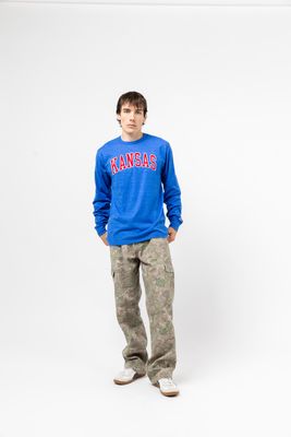 a young man in a kansas sweatshirt and camo pants