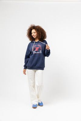 a woman wearing a blue sweatshirt and white pants