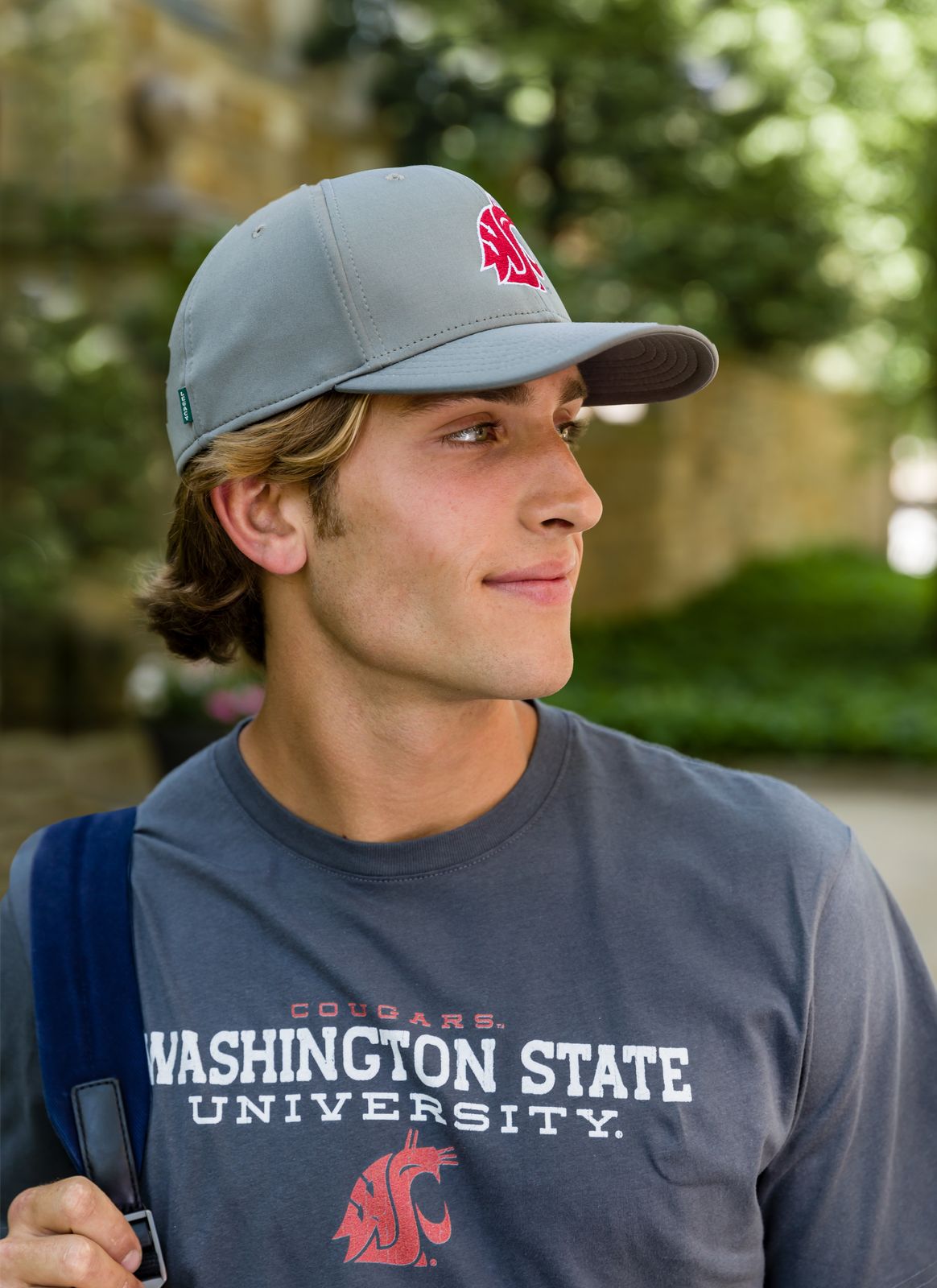 a young man wearing a washington state t - shirt and a hat