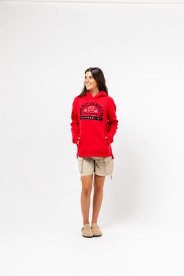 a woman wearing a red sweatshirt and tan shorts