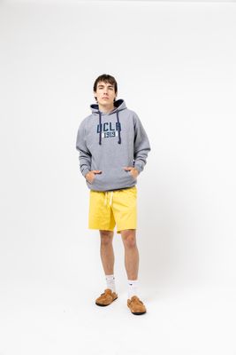 a man in a grey hoodie and yellow shorts