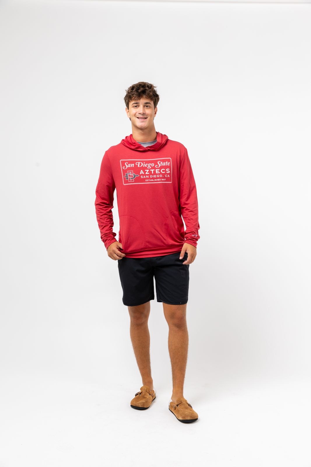 a young man in a red hoodie poses for a picture