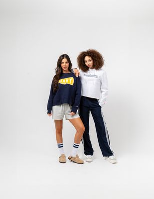 two women standing next to each other in front of a white background