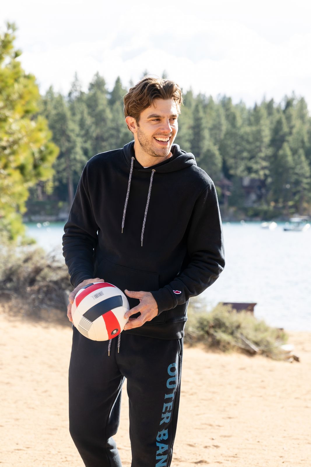 a man holding a ball on a beach