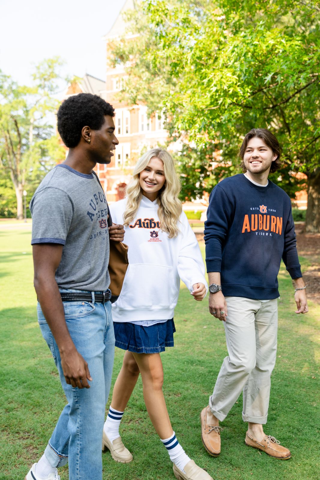 a group of young people standing on top of a lush green field