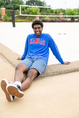 a man sitting on a ledge with his legs crossed
