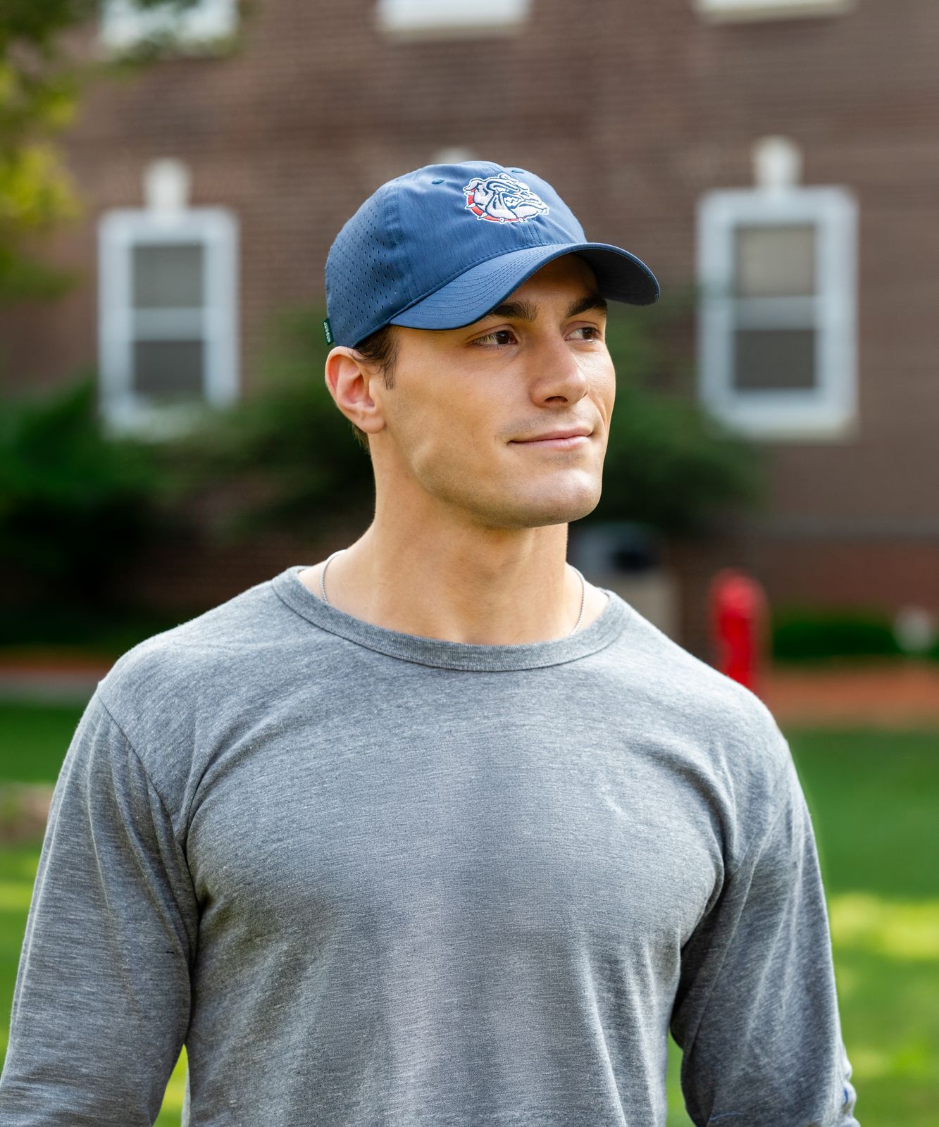 a man wearing a hat standing in front of a building