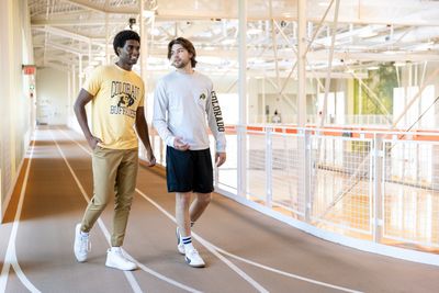 a couple of men standing next to each other on a track