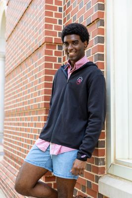a man standing next to a brick building