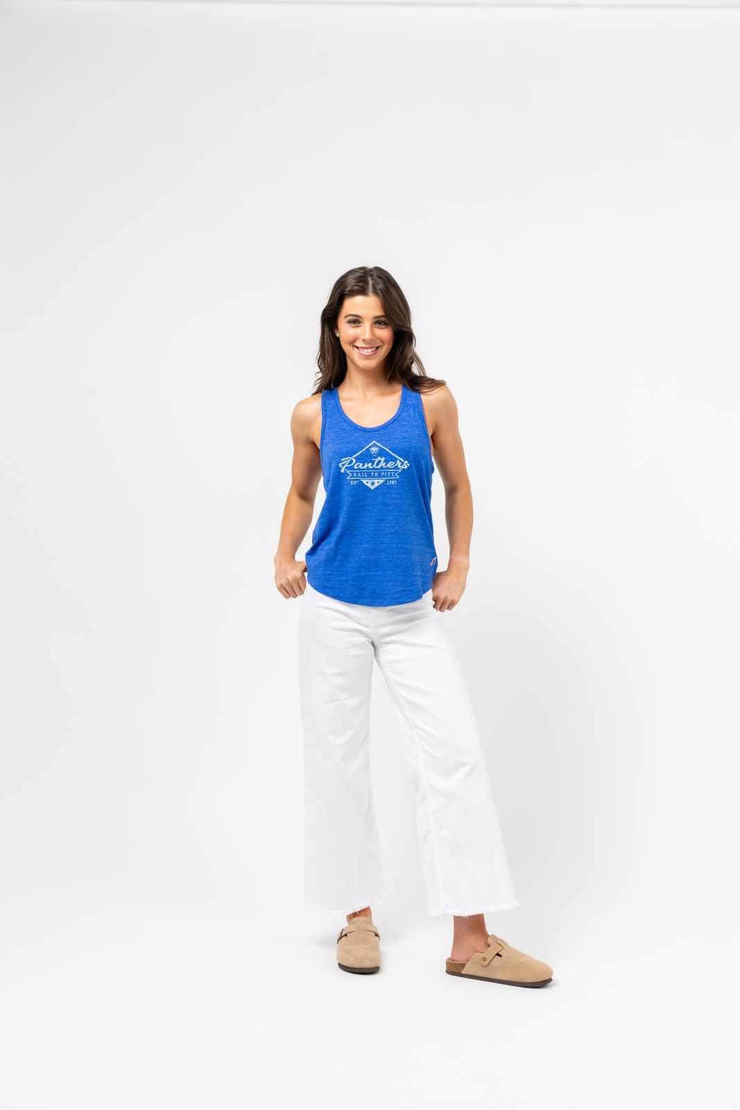 a woman in a blue tank top and white pants
