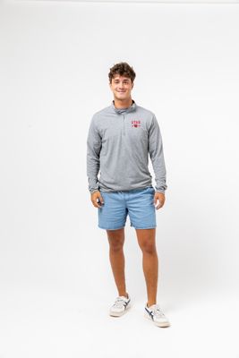 a man in a gray shirt and blue shorts