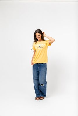 a woman in a yellow shirt and blue jeans