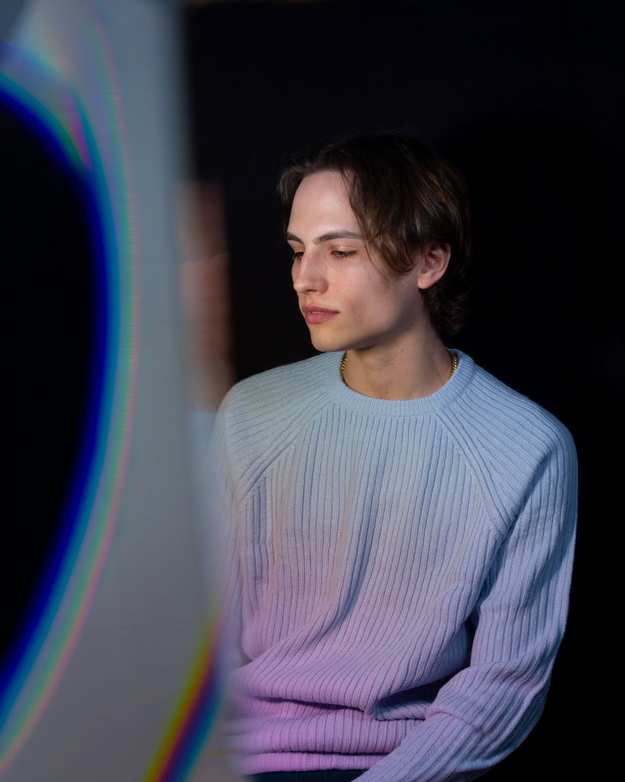 a man in a blue sweater looking at a laptop