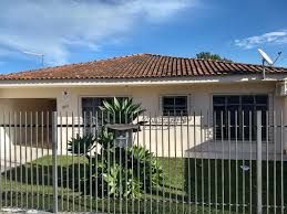 a house behind a fence with a bird on top of it