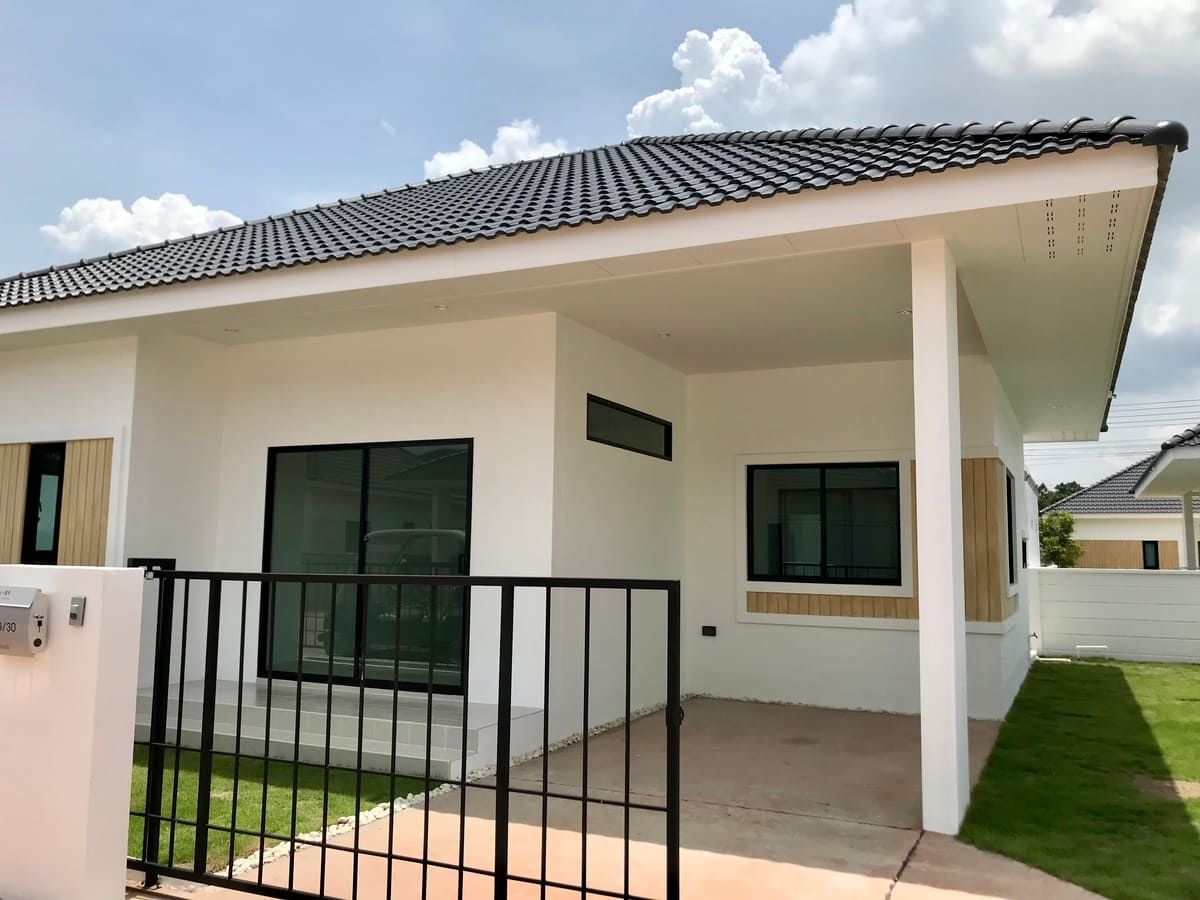 a small white house with a black fence