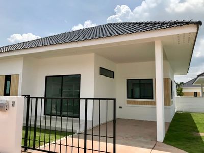 a small white house with a black fence