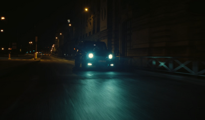 a truck driving down a street at night