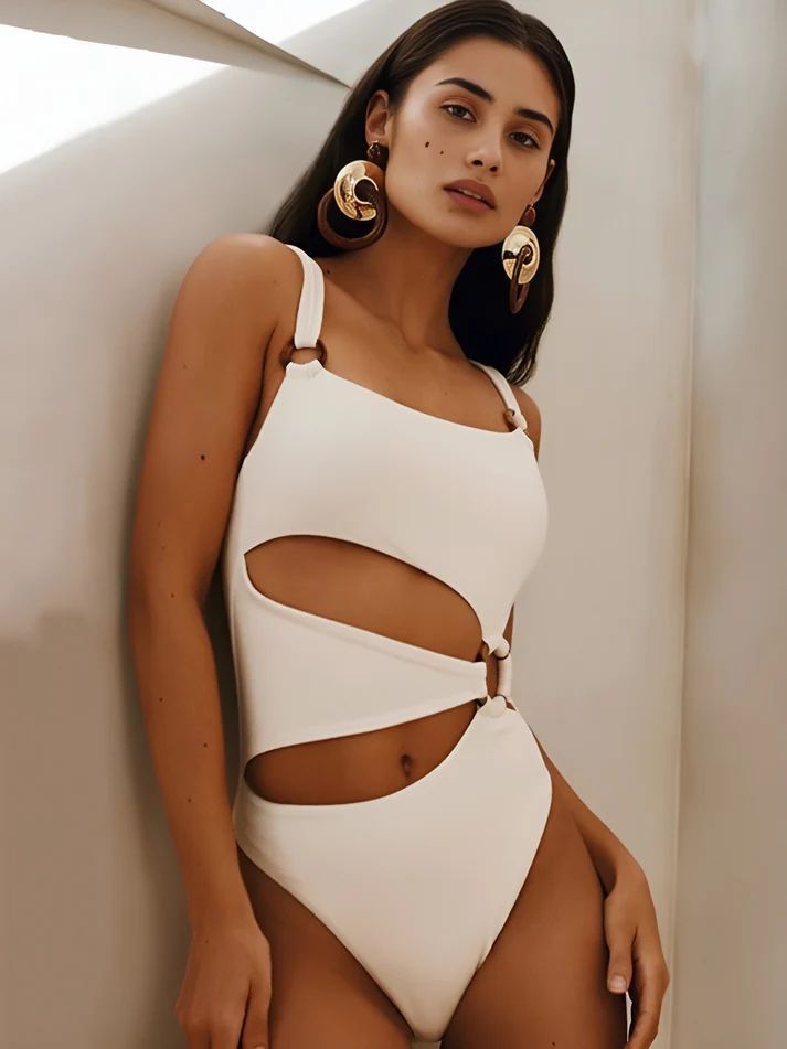 a woman in a white bodysuit leaning against a wall