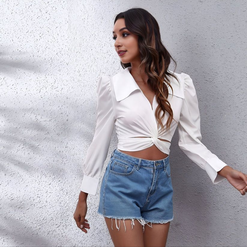 a woman wearing a white shirt and denim shorts
