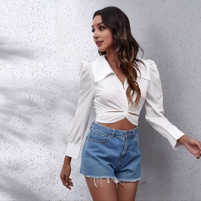a woman wearing a white shirt and denim shorts