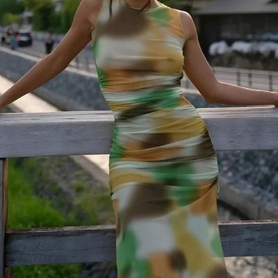 a woman in a dress leaning on a rail