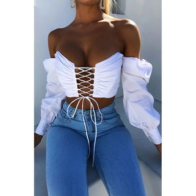 a woman wearing a white top and jeans