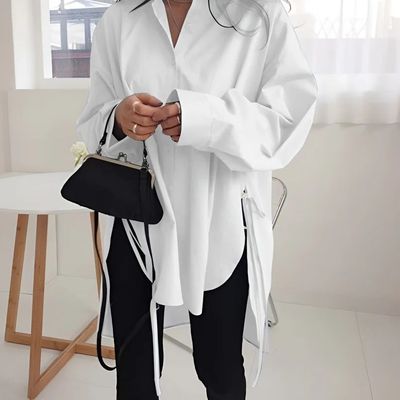 a woman in a white shirt holding a black purse