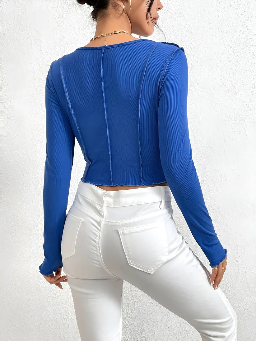 a woman wearing white pants and a blue top
