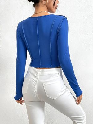 a woman wearing white pants and a blue top