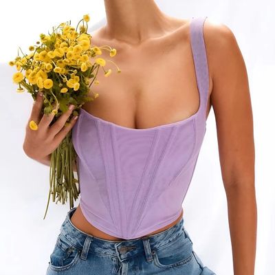 a woman in a corset holding a bouquet of flowers