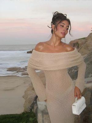a woman in a white dress standing on a beach
