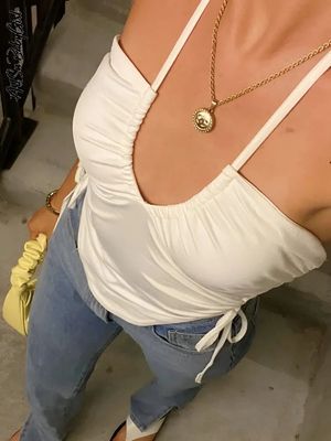 a woman wearing a white top and jeans