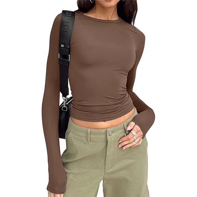 a woman wearing a brown shirt and green pants