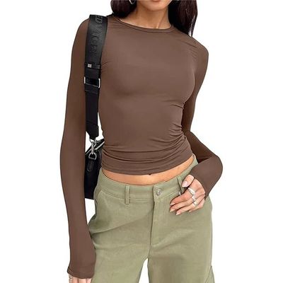 a woman wearing a brown shirt and green pants