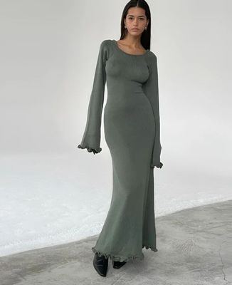 a woman in a long green dress posing for a picture