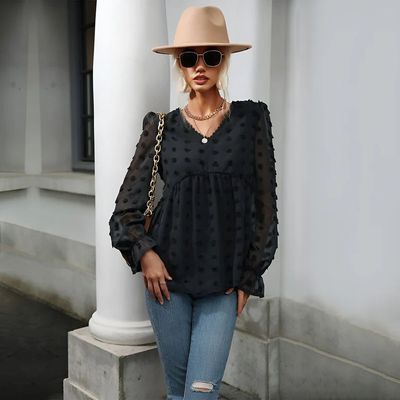 a woman standing next to a pillar wearing a hat and sunglasses