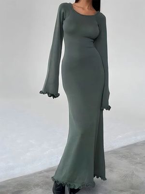 a woman in a green dress posing for a picture