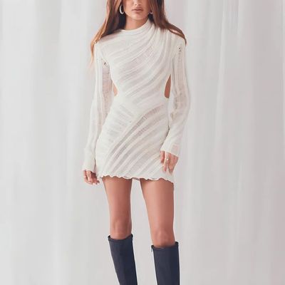 a woman in a white dress and knee high boots