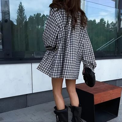 a woman in a plaid coat and black boots