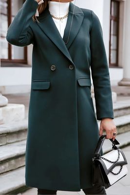 a woman in a green coat is talking on a cell phone