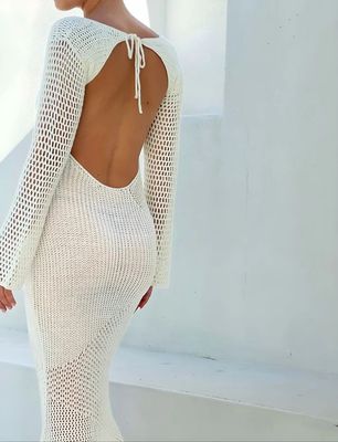 a woman wearing a white dress with open back